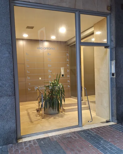 Vestíbul del Carrer Vila Antònia, 1, amb el rètol de Gestoria Batlle al panell del 2n